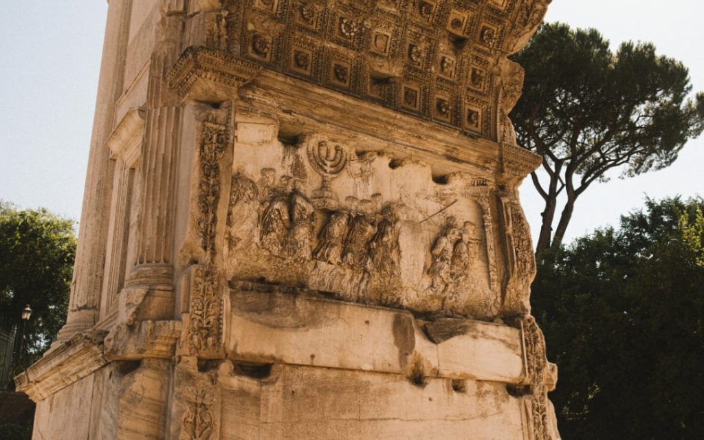 Antyczna płaskorzeźba wewnątrz Łuku Tytusa przedstawiająca rzymski orszak triumfalny niosący siedmioramienny świecznik (menorę) ze zdobytej Świątyni w Jerozolimie