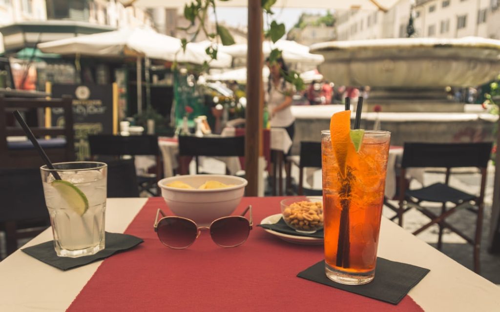 Aperol spritz i rzymskie przekąski w kawiarnianym ogródku na placu Campo de' Fiori w Rzymie