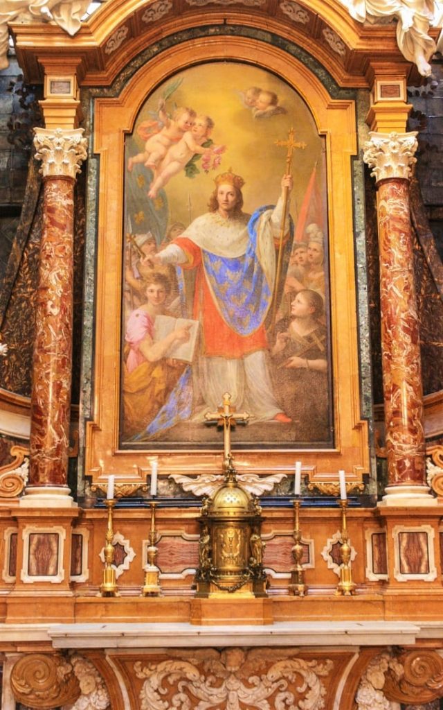 Barokowy ołtarz z obrazem św. Ludwika Króla Francji w otoczeniu aniołów, umieszczony między marmurowymi kolumnami