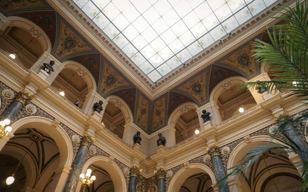Pięknie zdobiony sufit z rzeźbami i dużymi oknami, wpuszczającymi naturalne światło
