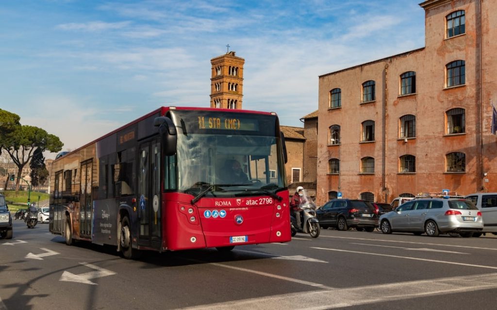 Czerwony autobus komunikacji miejskiej na drodze w Rzymie