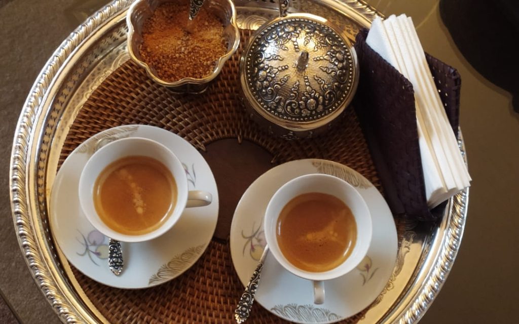 Dwie filiżanki espresso z cremą na ozdobnej srebrnej tacy w rzymskiej kawiarni