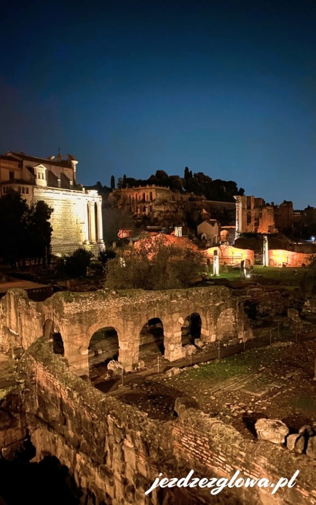 Forum Romanum nocą z oświetlonymi ruinami i widokiem na Palatyn w Rzymie