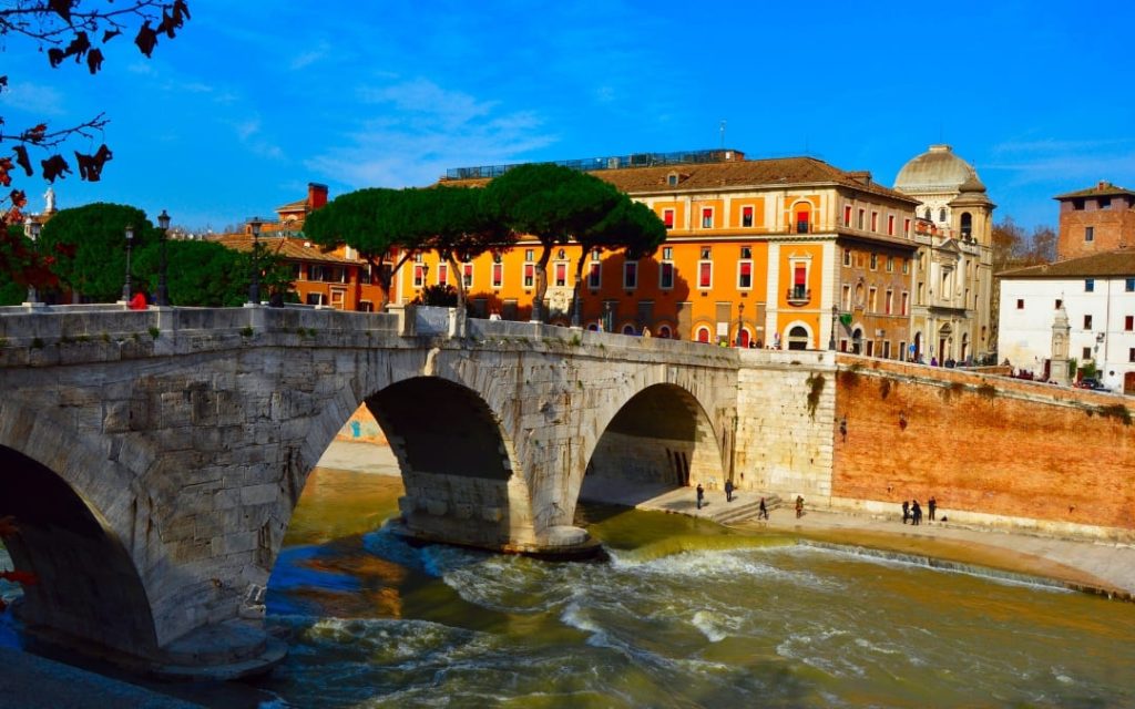 Historyczny most Ponte Cestio prowadzący na Wyspę Tyberyjską w Rzymie w pełnym słońcu