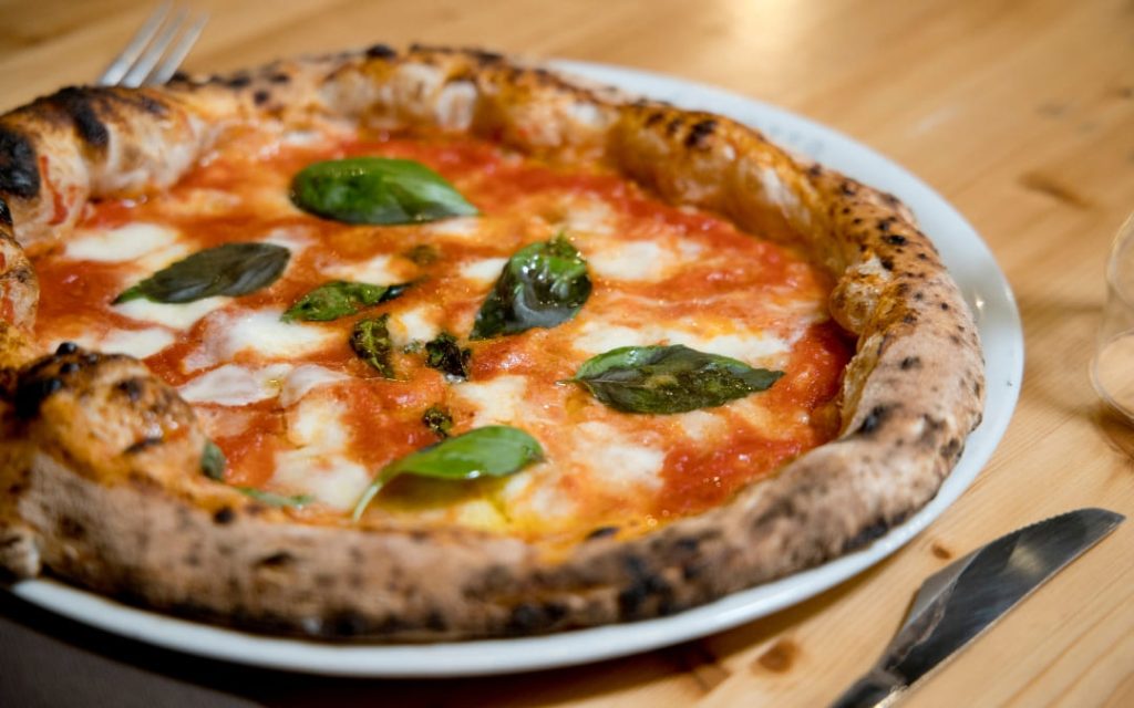 Klasyczna pizza margherita z mozzarellą świeżą bazylią i sosem pomidorowym na puszystym cieście