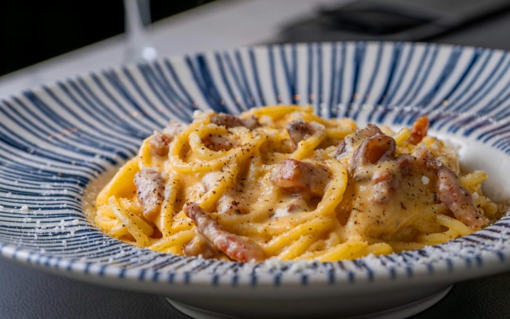 Klasyczny rzymski makaron spaghetti carbonara z chrupiącym guanciale i serem pecorino