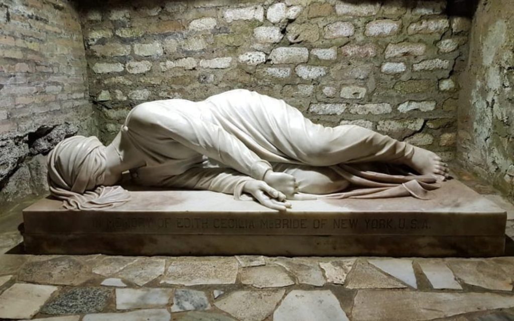 Marmurowa rzeźba leżącej świętej Cecylii w rzymskich Katakumbach św. Kaliksta na tle ceglanego muru