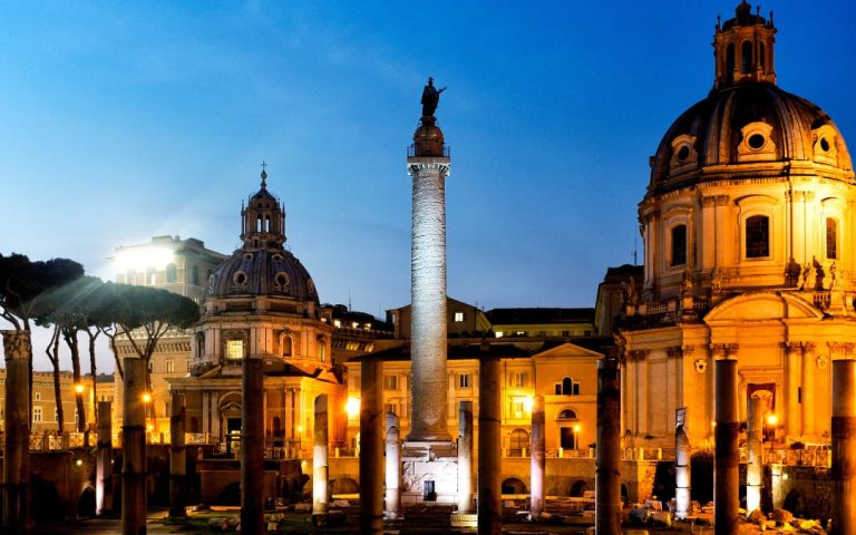 Nocny widok na Forum Trajana w Rzymie z podświetloną Kolumną Trajana i kościołem Najświętszego Imienia Maryi