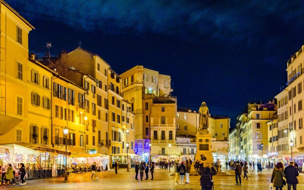 Oświetlony plac Campo de' Fiori w Rzymie wieczorem z pomnikiem Giordana Bruna w centralnej części