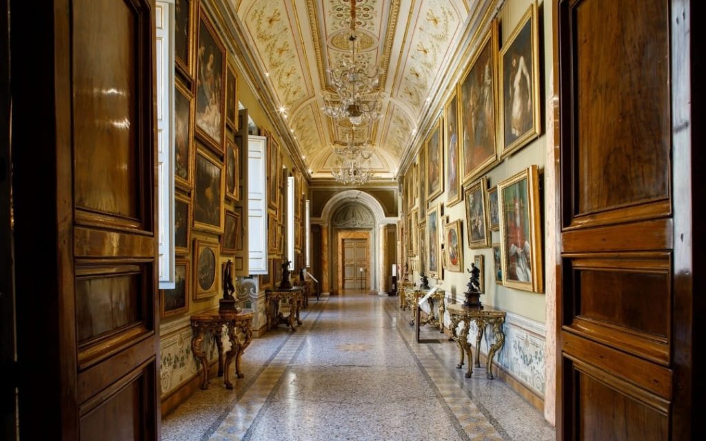 Perspektywa bogato zdobionej galerii obrazów w Palazzo Barberini z kunsztownym sufitem i złoconymi ramami