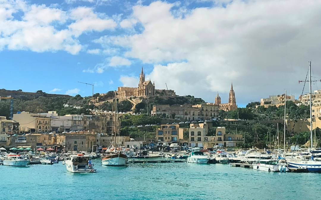 Port w miejscowości na Gozo, z widokiem na wzgórze z kościołem i otaczającymi budynkami