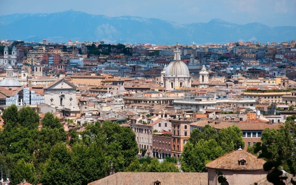 Rozległa panorama Rzymu z tarasu widokowego Gianicolo z widocznymi kopułami kościołów i dachami kamienic