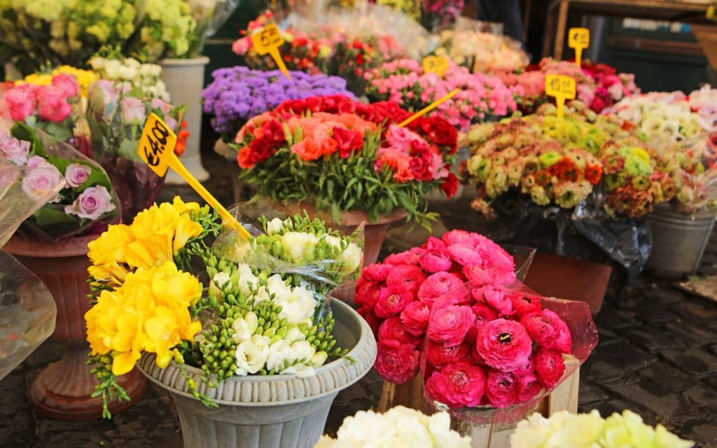 Świeże bukiety frezji, jaskrów i róż na historycznym rzymskim targu kwiatowym