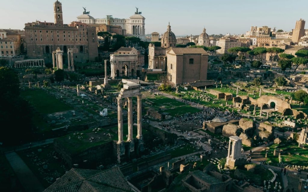Szeroki widok na Forum Romanum w Rzymie z ruinami świątyń, łukiem Septymiusza Sewera i widocznym w tle monumentalnym Ołtarzem Ojczyzny