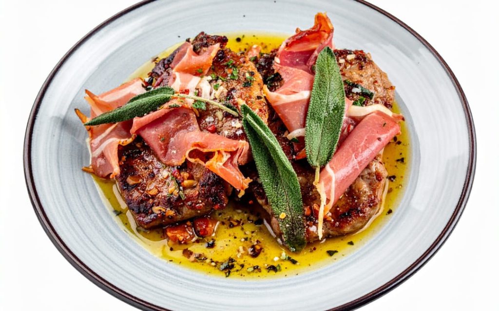 Tradycyjne saltimbocca alla romana z cielęciną, szynką parmeńską i szałwią w maślanym sosie