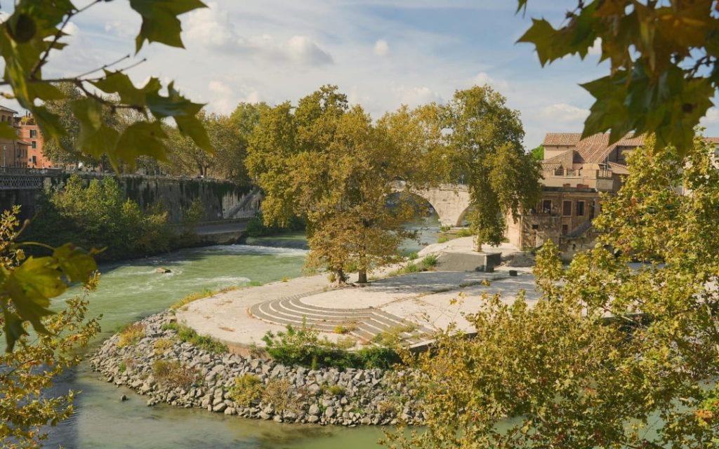 Widok na cypel Wyspy Tyberyjskiej w Rzymie z rzeką Tyber i kamiennym mostem Ponte Cestio w tle