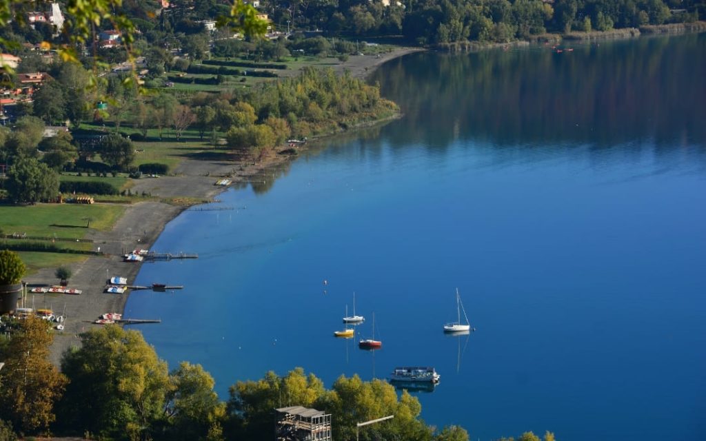 Widok na jezioro wulkaniczne Albano z żaglówkami i zielonymi wzgórzami Lacjum