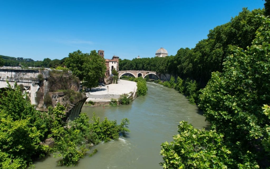 Widok na rzekę Tyber z ruinami starożytnego mostu Ponte Rotto i kopułą Wielkiej Synagogi w Rzymie