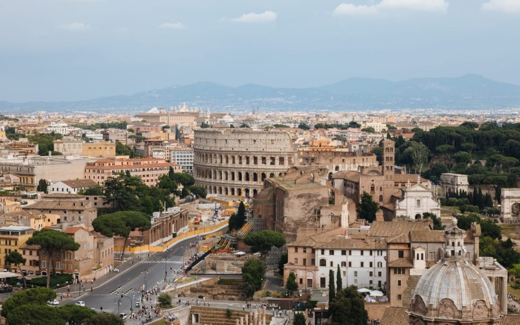 Widok z góry na Koloseum i Via dei Fori Imperiali w Rzymie w słoneczny dzień