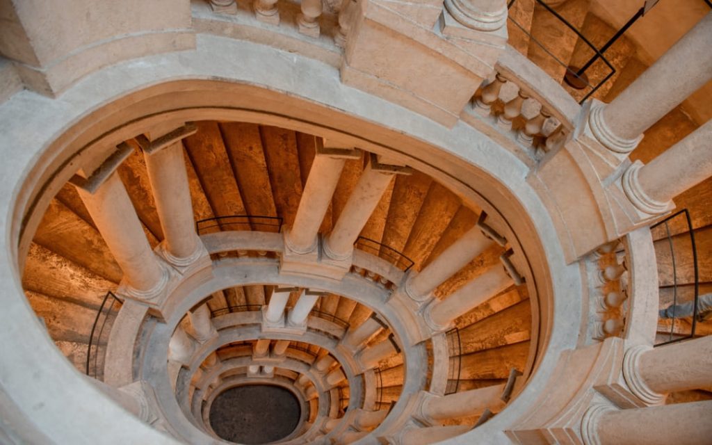 Widok z góry na barokowe, eliptyczne schody spiralne projektu Borrominiego w Palazzo Barberini