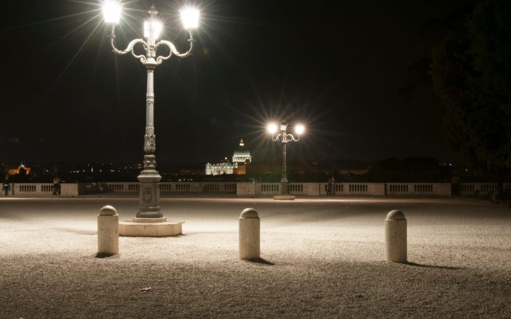 Widok z tarasu Terrazza del Pincio w Rzymie na oświetloną Bazylikę św. Piotra w oddali w nocy
