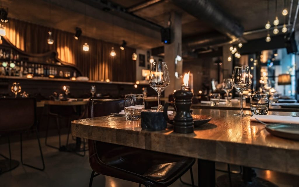 Wnętrze klimatycznej restauracji w Rzymie z drewnianymi stołami i nastrojowym barem