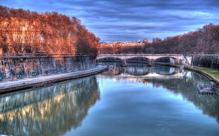Zabytkowy most Ponte Umberto I nad rzeką Tyber w Rzymie w jesiennej scenerii