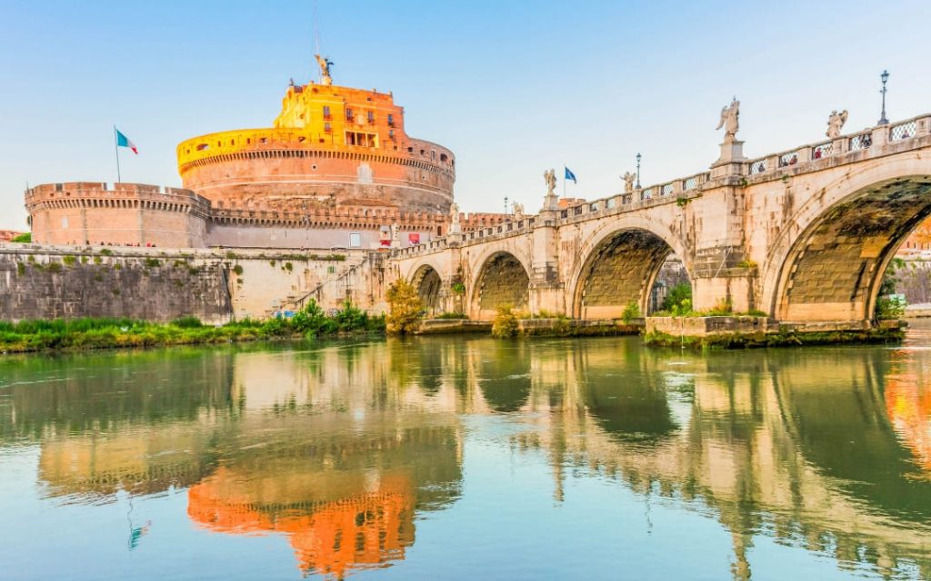 Zamek Świętego Anioła i most Ponte Sant'Angelo odbijające się w tafli rzeki Tyber w Rzymie