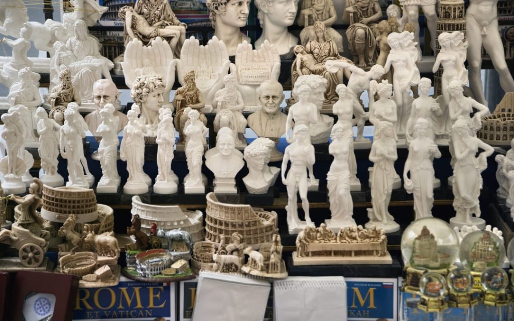 Zbiór miniaturowych rzeźb antycznych bóstw i popiersi sławnych postaci na wystawie sklepowej w Rzymie