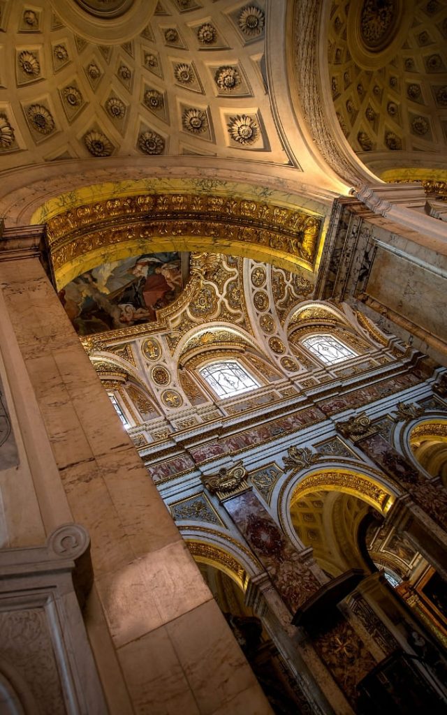 Złocone, kasetonowe sklepienie i barokowe łuki wnętrza kościoła San Luigi dei Francesi w Rzymie