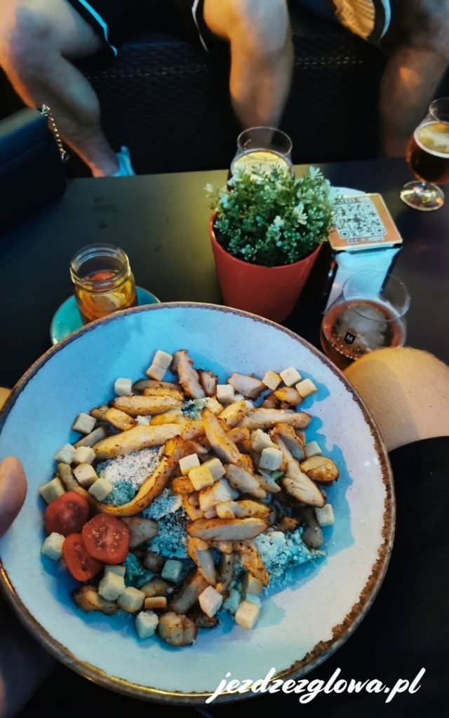 
Apetyczne danie z kurczakiem i warzywami podane na ceramicznym talerzu w wieczornym świetle.
