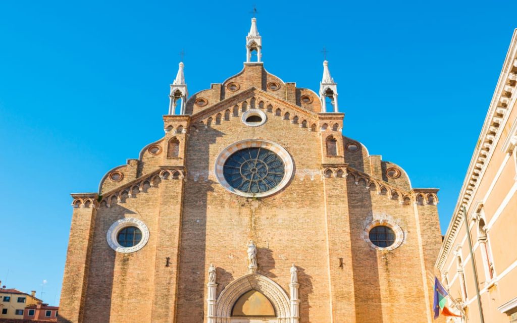 Bazylika Santa Maria Gloriosa dei Frari - masywna ceglana świątynia z rozetowymi oknami i gotyckimi detalami 