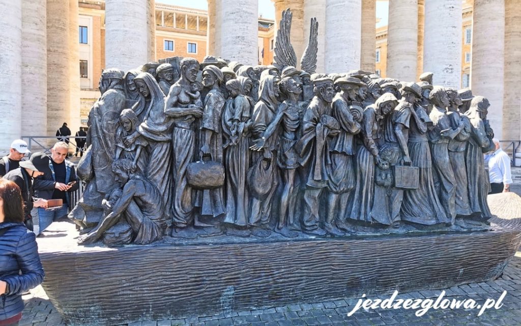 Brązowa rzeźba _Angels Unawares_ na Placu Świętego Piotra przedstawiająca tłum migrantów z aniołem