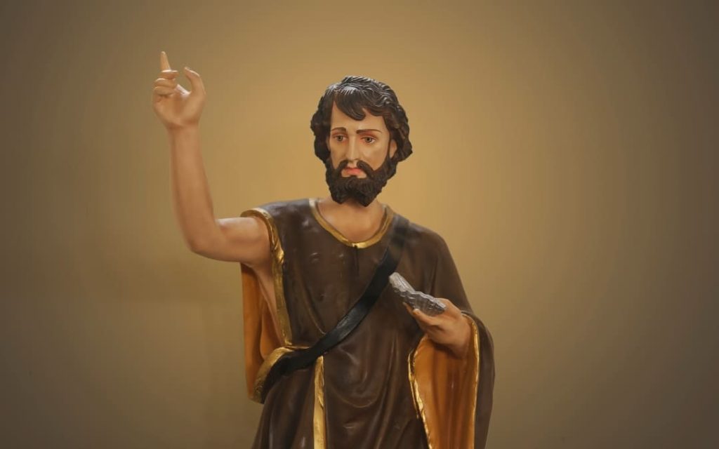 Kolorowa figura Jana Chrzciciela z uniesionym palcem i księgą w złoto-brązowej szacie