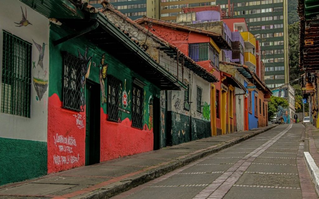 Kolorowa ulica z tradycyjną, kolonialną zabudową i muralami w jednym z miast Kolumbii.