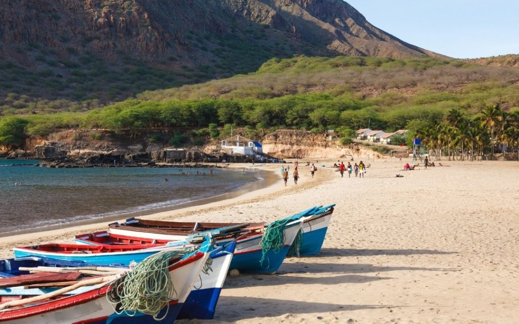 Kolorowe łodzie rybackie na piaszczystej plaży nad błękitnym oceanem na Wyspach Zielonego Przylądka.