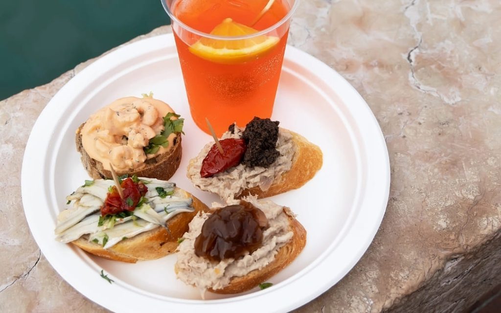 Małe weneckie przekąski - grzanki z owocami morza, pastami rybnymi i warzywami, podane z Aperol Spritz