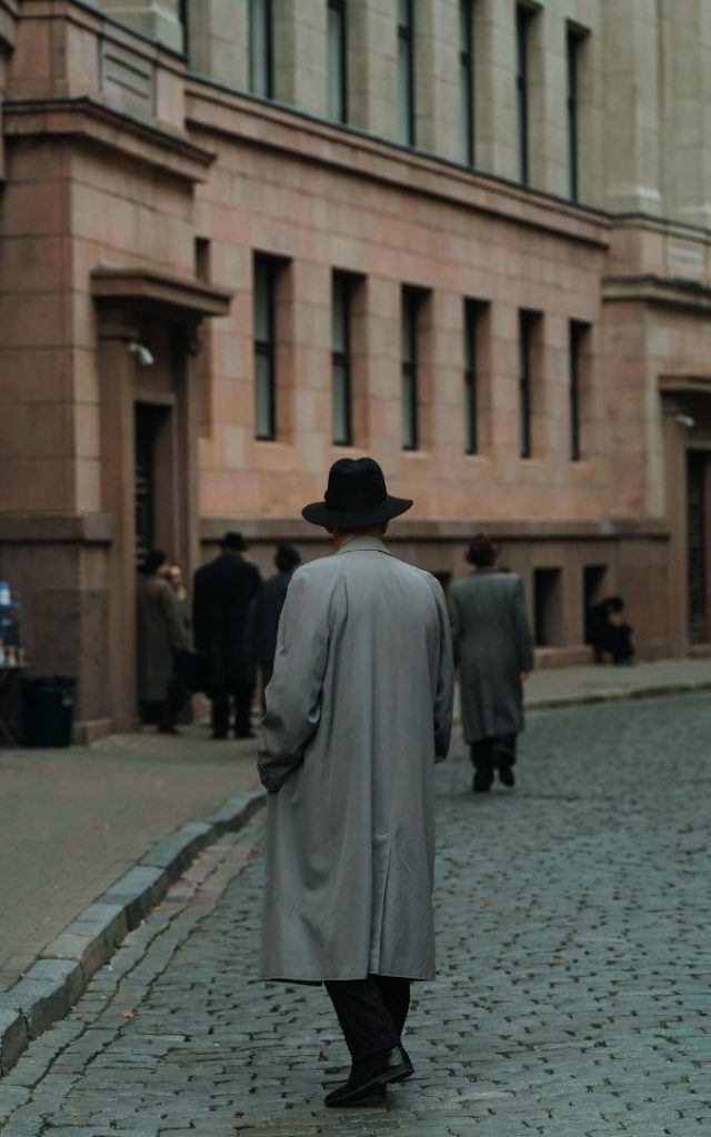 Mężczyzna w płaszczu przechadzający się po ulicy