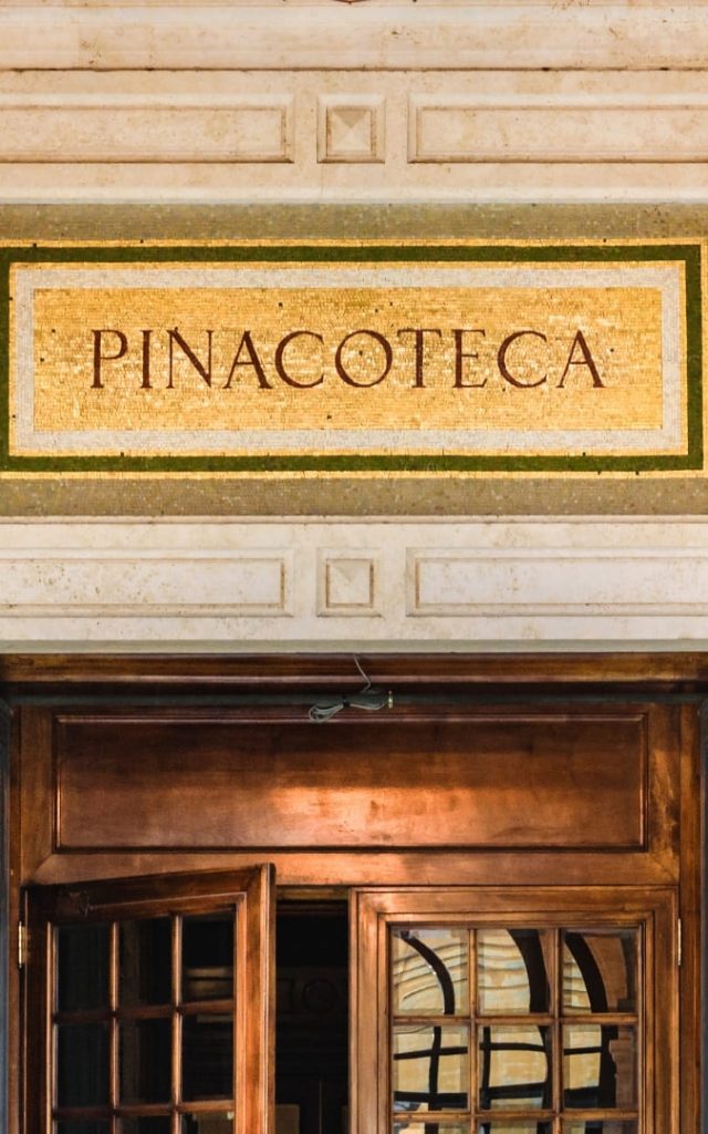 Mozaikowy szyld z napisem Pinacoteca nad drewnianymi drzwiami wejściowymi do Pinakoteki Watykańskiej w Watykanie