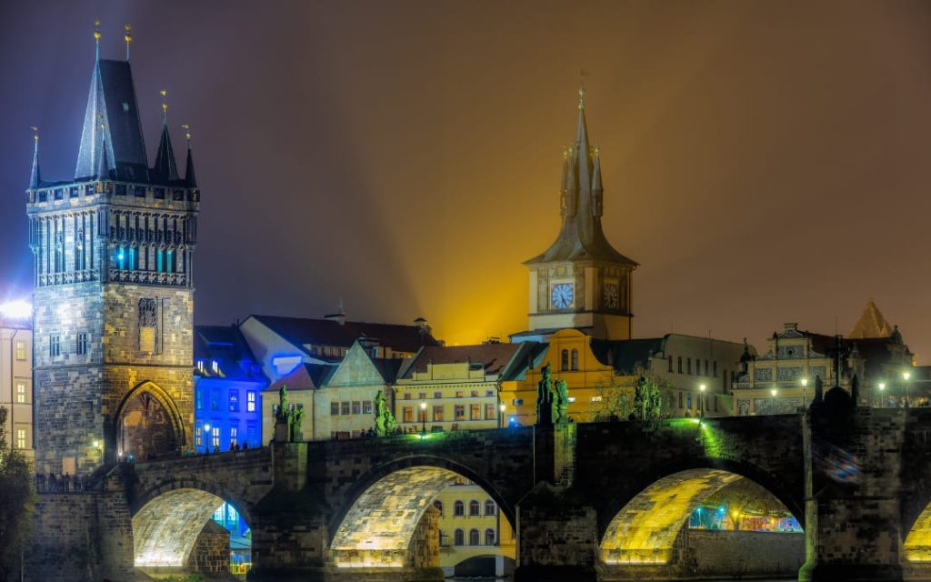 Nocna panorama Mostu Karola w Pradze z podświetloną Wieżą Mostową Starego Miasta