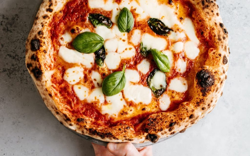 Pizza margherita z mozzarellą i sosem pomidorowym widoczna z góry