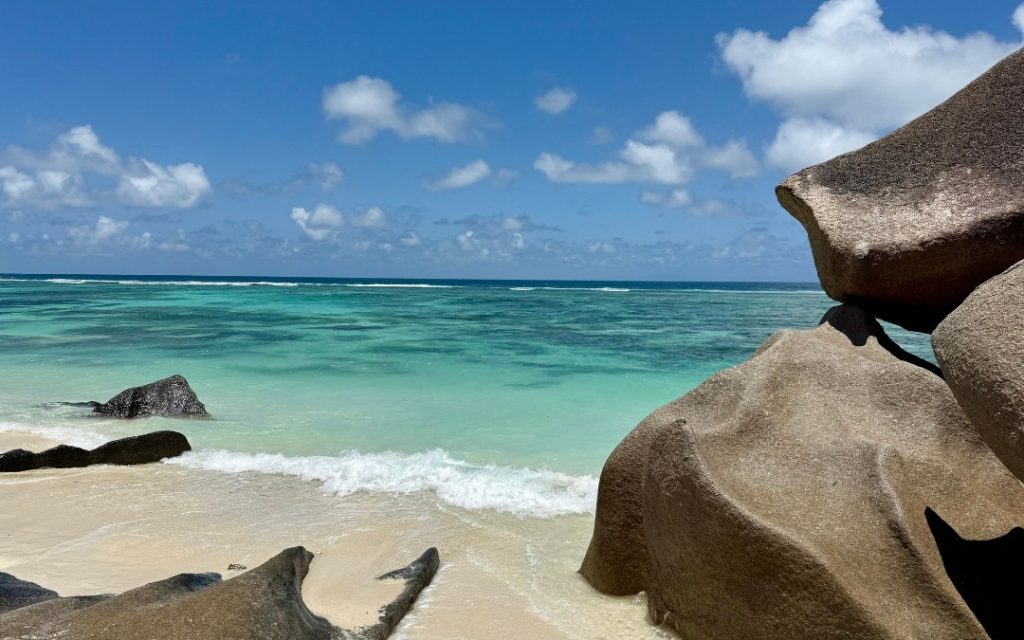Rajska plaża na Szeszelach z białym piaskiem i ogromnymi, gładkimi głazami granitowymi.