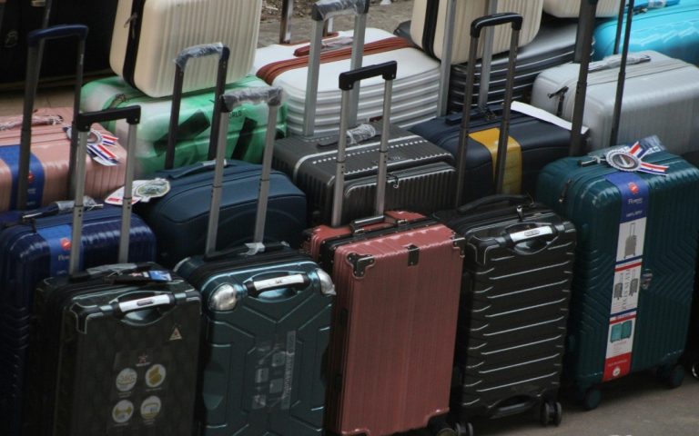 Różnokolorowe, nowoczesne walizki kabinowe i podróżne ustawione obok siebie, gotowe do transportu.