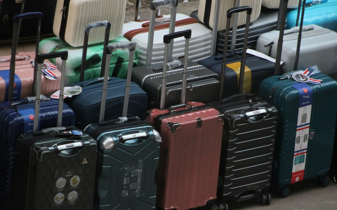 Różnokolorowe, nowoczesne walizki kabinowe i podróżne ustawione obok siebie, gotowe do transportu.