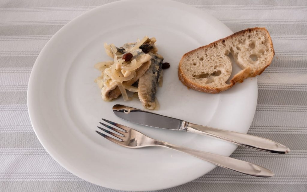 Sarde in saor, włoska przystawka ze smażonych sardynek z cebulą w słodko - kwaśnej zalewie, orzeszkami pinii i rodzynkami
