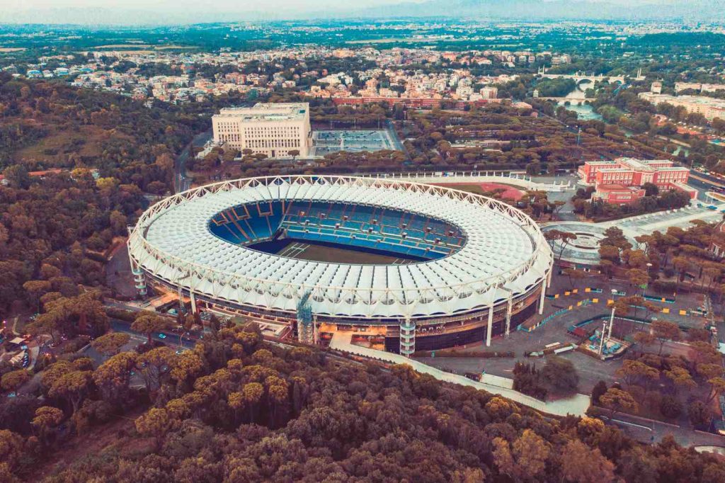 Stadio Olimpico w Rzymie widziane z lotu ptaka, otoczone zielenią i zabudową włoskiej stolicy.