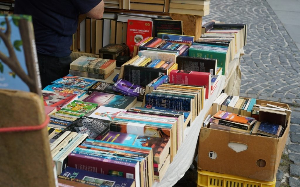 Uliczne stoisko wypełnione rzędami różnorodnych książek, przygotowane dla mieszkańców i turystów z okazji barcelońskiego święta literatury i miłości.
