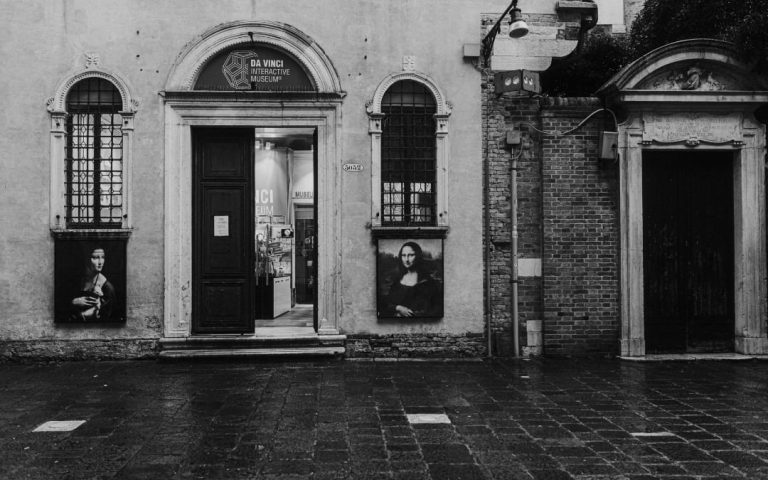 Wejście do Muzeum Leonarda da Vinci z reprodukcjami obrazów na fasadzie starej kamienicy