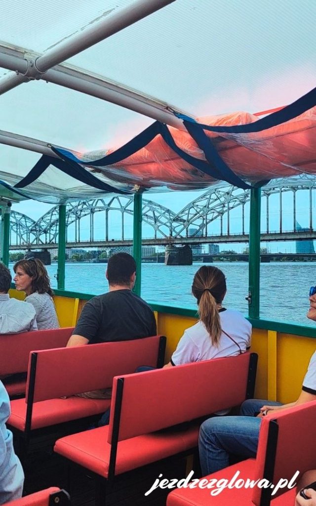 Widok na Dźwinę z wnętrza ryskiego tramwaju wodnego z charakterystycznymi czerwonymi siedzeniami