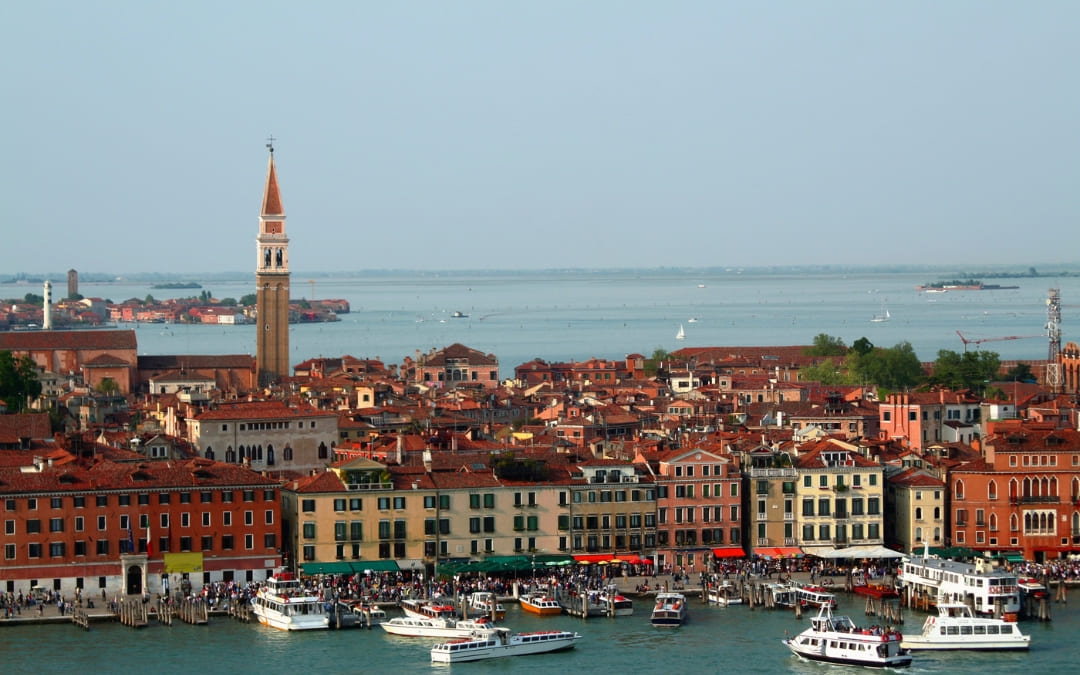 Widok na Riva degli Schiavoni w Wenecji z kolorowymi kamienicami, turystami i łodziami przy brzegu